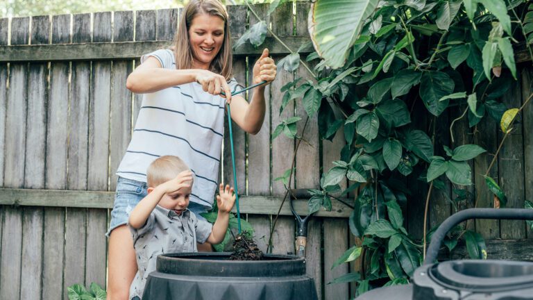 Mother and son mix the compost in their bin.